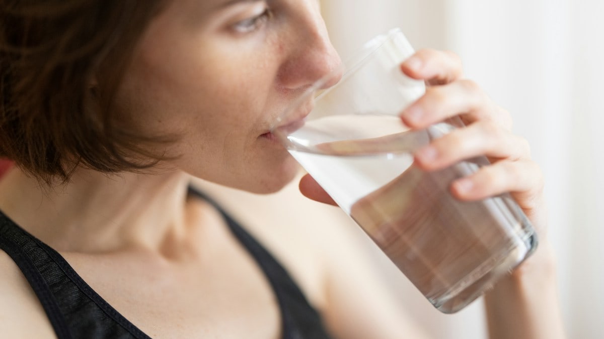 a woman drinking a glass of fresh water